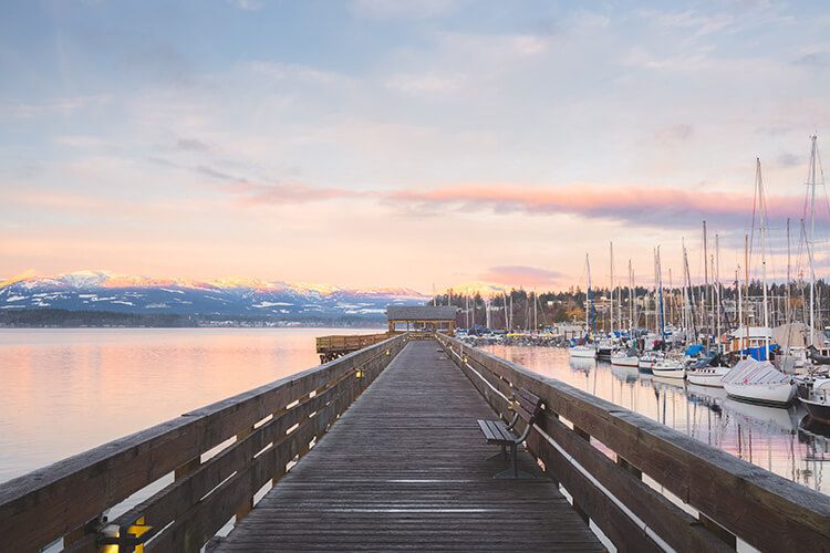 Comox waterfront walkway and sunrise and marina in the background