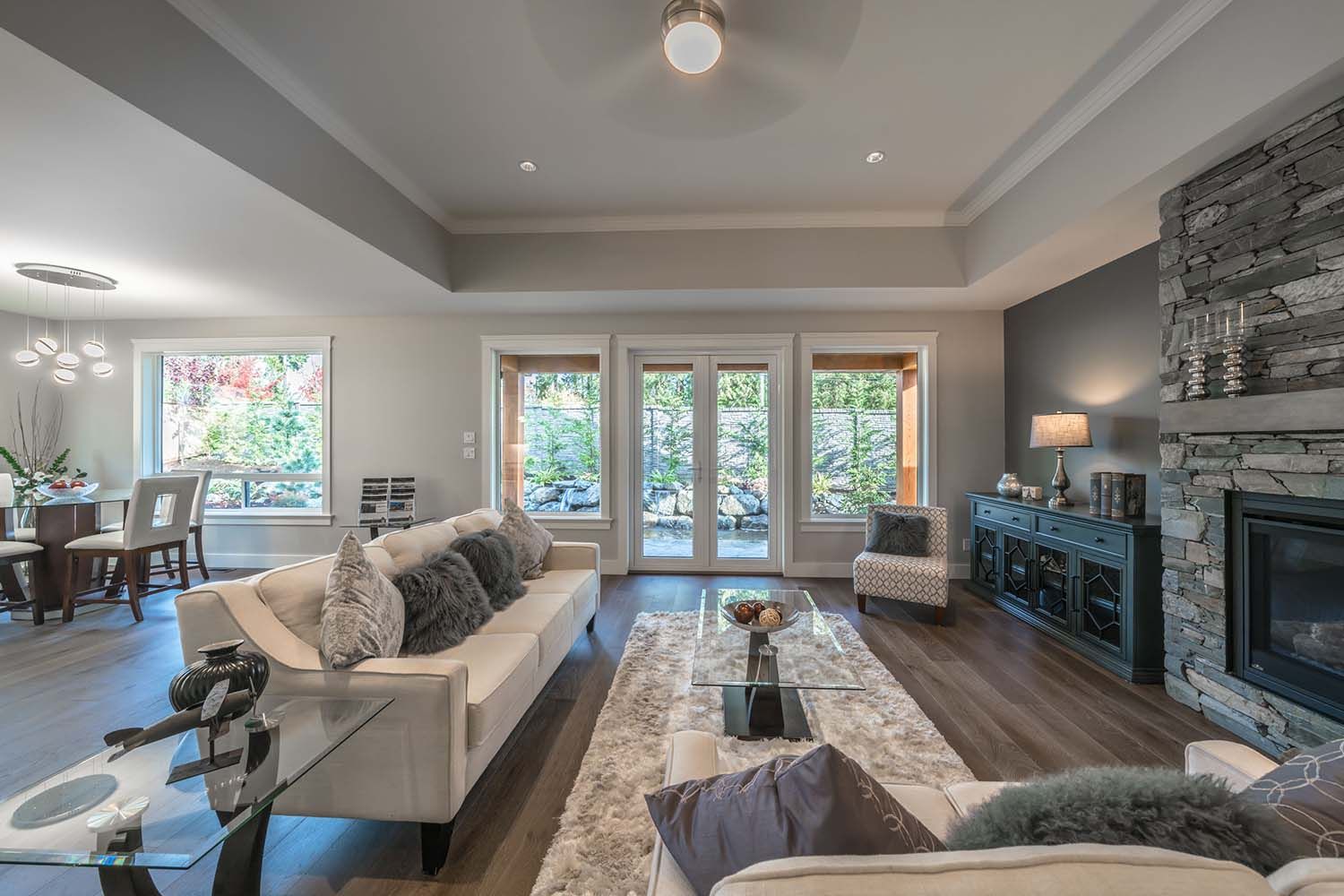 Large living room with couches and doors opening to a deck