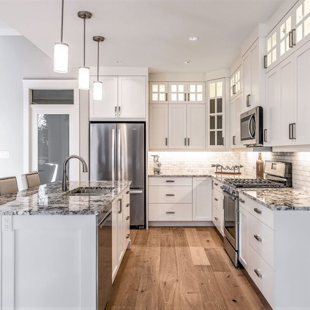 Kitchen with metal appliances and wooden flooring