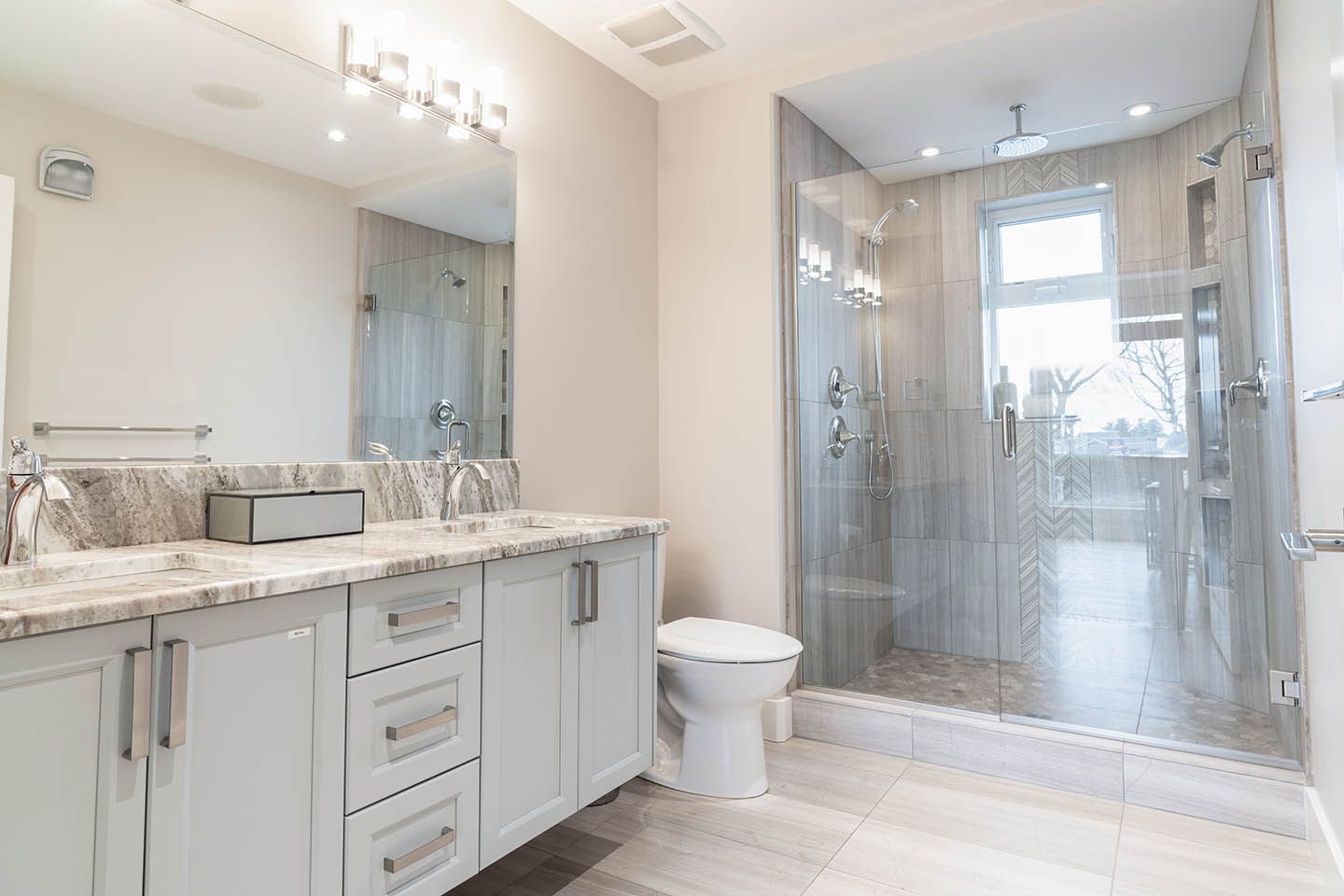 Bathroom with white cabinets and shower with glass door