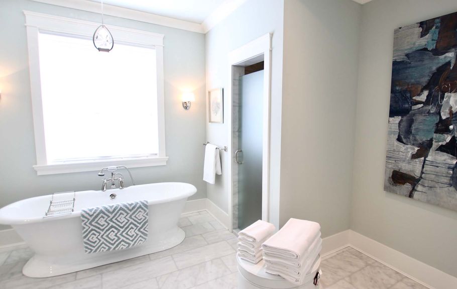 White bathroom with a bath in front of a window