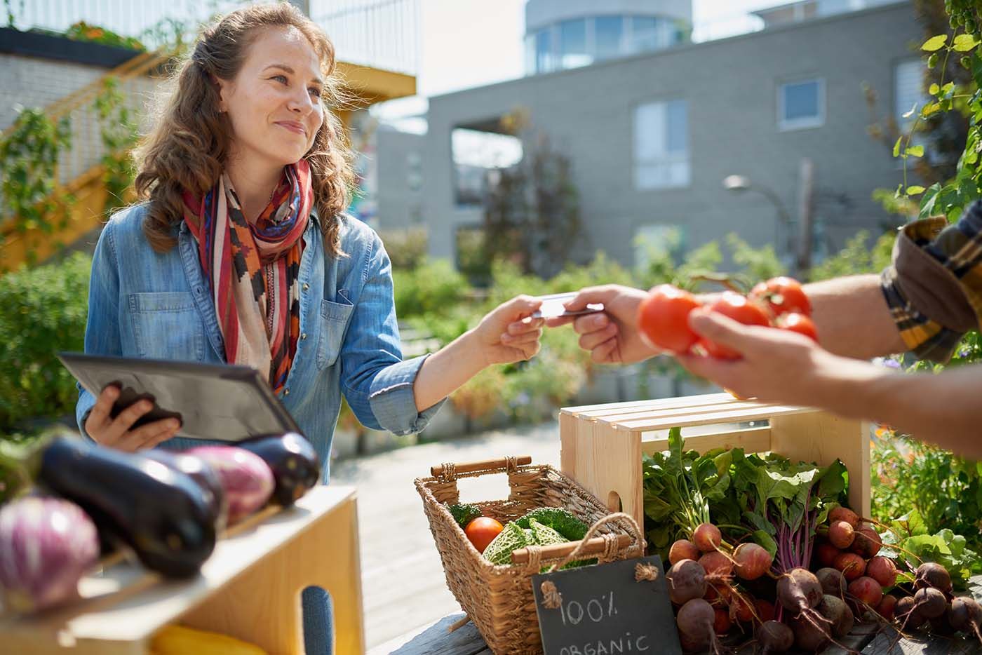 Woman purchases vegetables at farm market