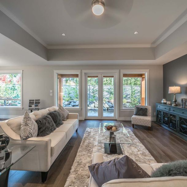 Large living room with couches and doors opening to a deck