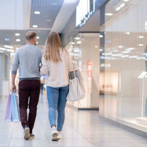 Couple walking down walkway of shopping mall