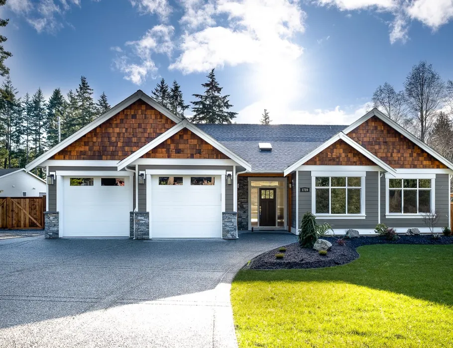 Front of house with double garag, grey roof and wooden paneling