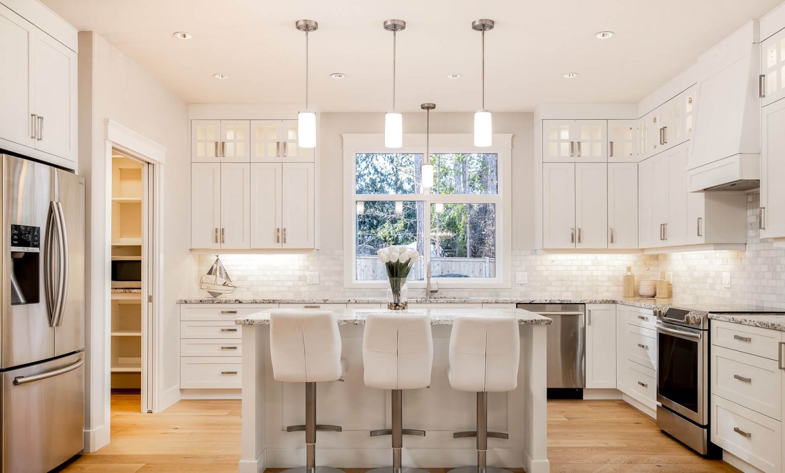 A beautiful white and bright kitchen with island.