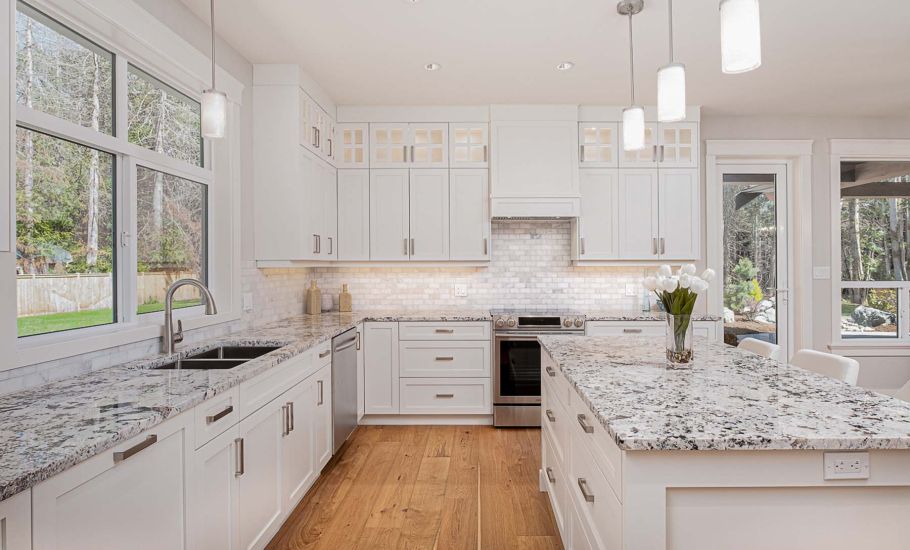 Kitchen with wooden flooring and cabinets with marble countertops