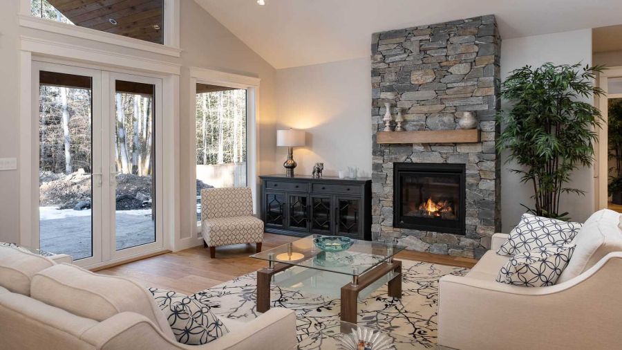 A beautiful family room with a show-stopping fireplace, high ceilings, and an inviting atmosphere. Designed by Ballard Fine Homes.