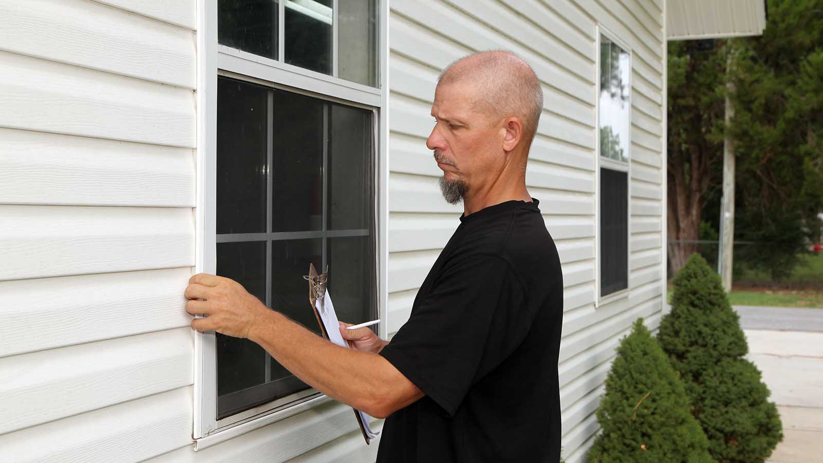 Home inspector examining windows for a new home owner.