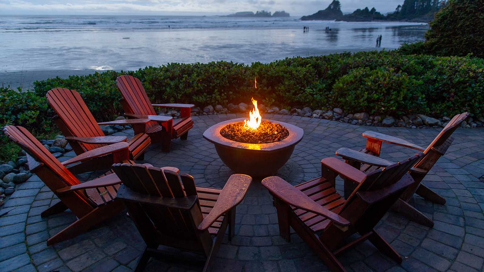 Chairs around a fire pit facing the beach on Vancouver Island. 