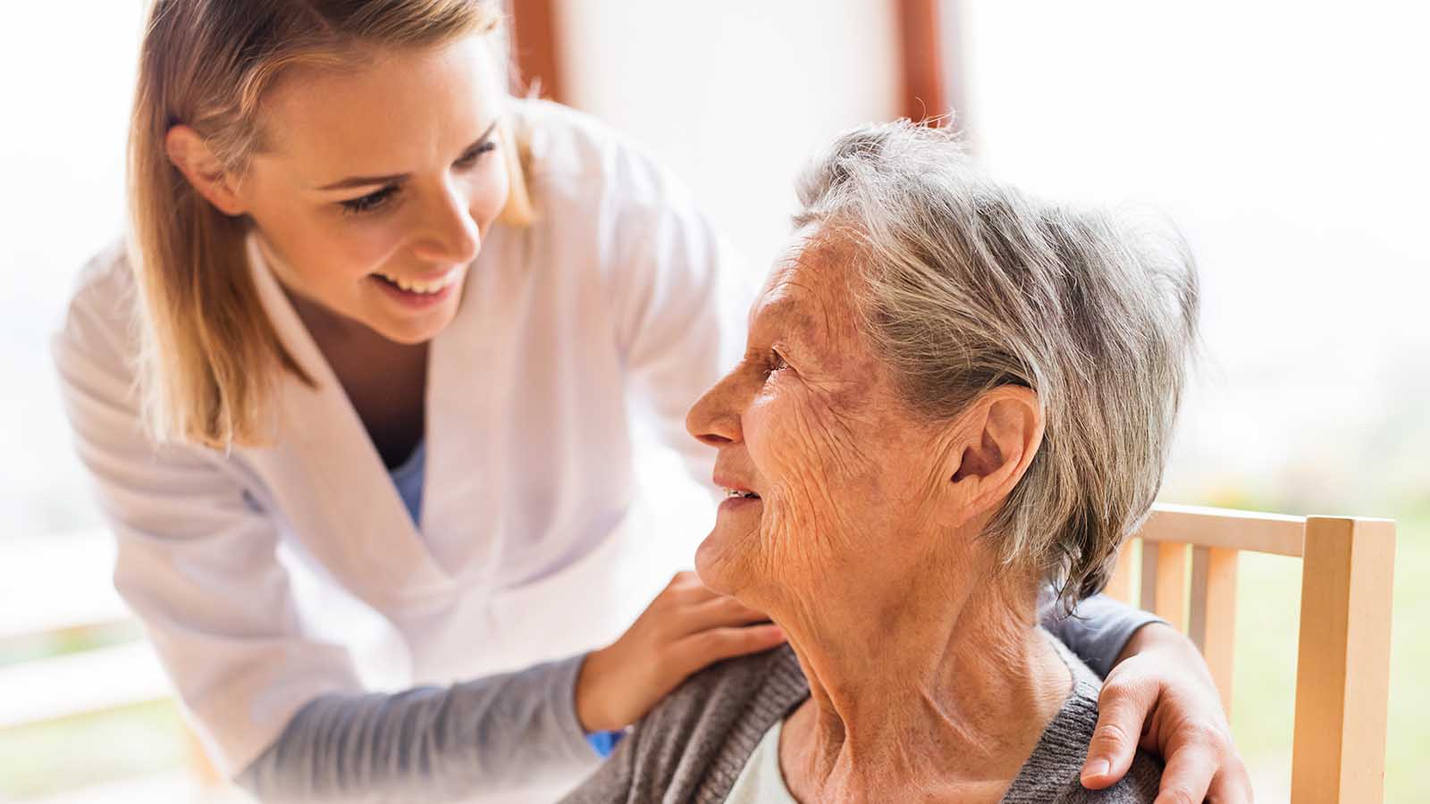 Health visitor and a senior woman during home visit.